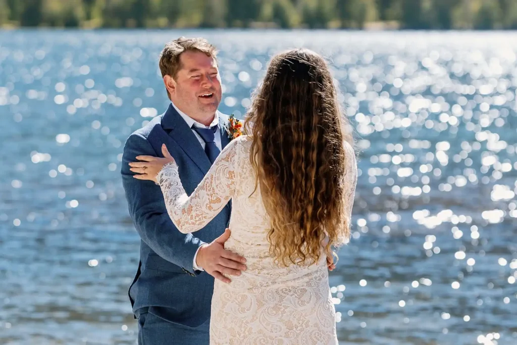 Emotional candid moment of an elopement couple sharing a first look at a high alpine lake