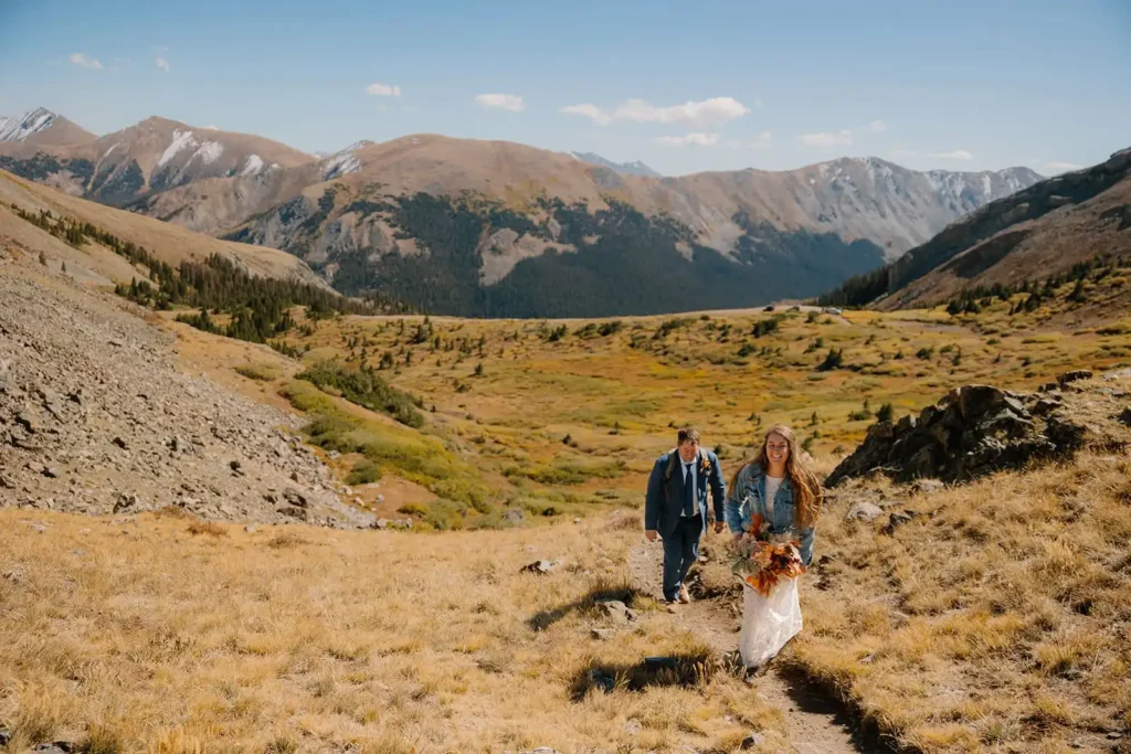 Couple hikes on their wedding day. Elopement detail inspiration and the best Colorado location
