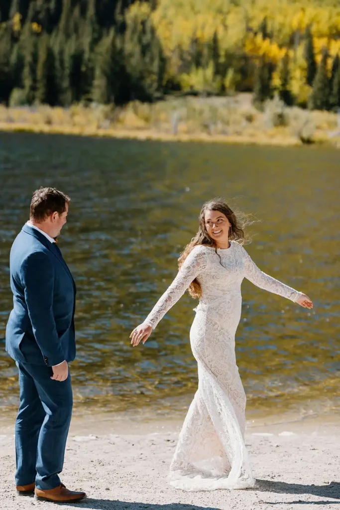 Authentic emotional moment of a couple on elopement day. Bride and groom see each other for the first time and bride spins in lace wedding dress