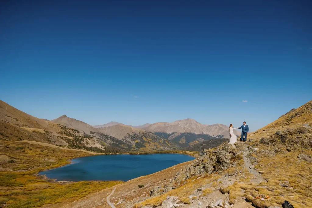 Stunning mountain landscape on an elopement day in Buena Vista Colorado. Bride and Groom hike with their dog.