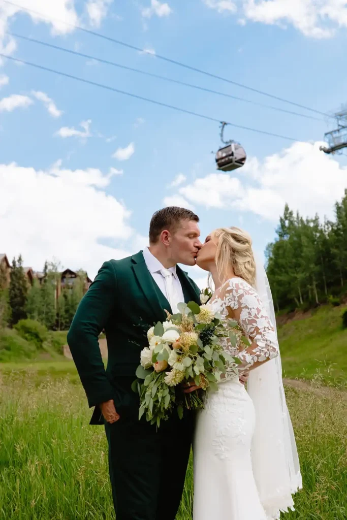 If you're looking for the best Telluride wedding photographer, consider Leah Lach, a true to color, documentary style yet also editorial style wedding photographer. She takes fun, candid, real, authentic, timeless wedding photos that will last a life time. Wedding couple kisses under mountain gondola in Telluride