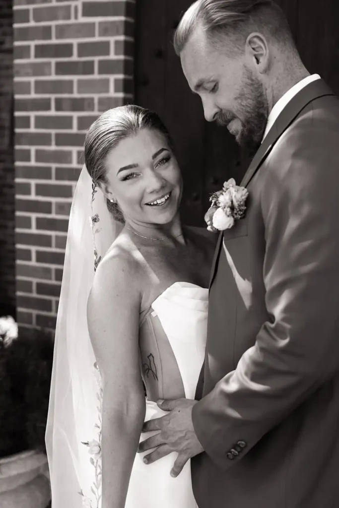 Wedding couple shares a candid moment while taking couple's portraits at Wellshire Event Center