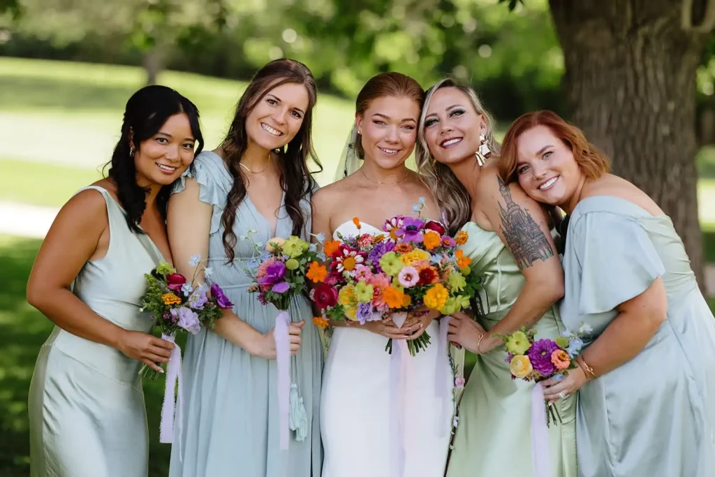 Brightly colored blue and green bridesmaids dresses for a summer Colorado outdoor wedding