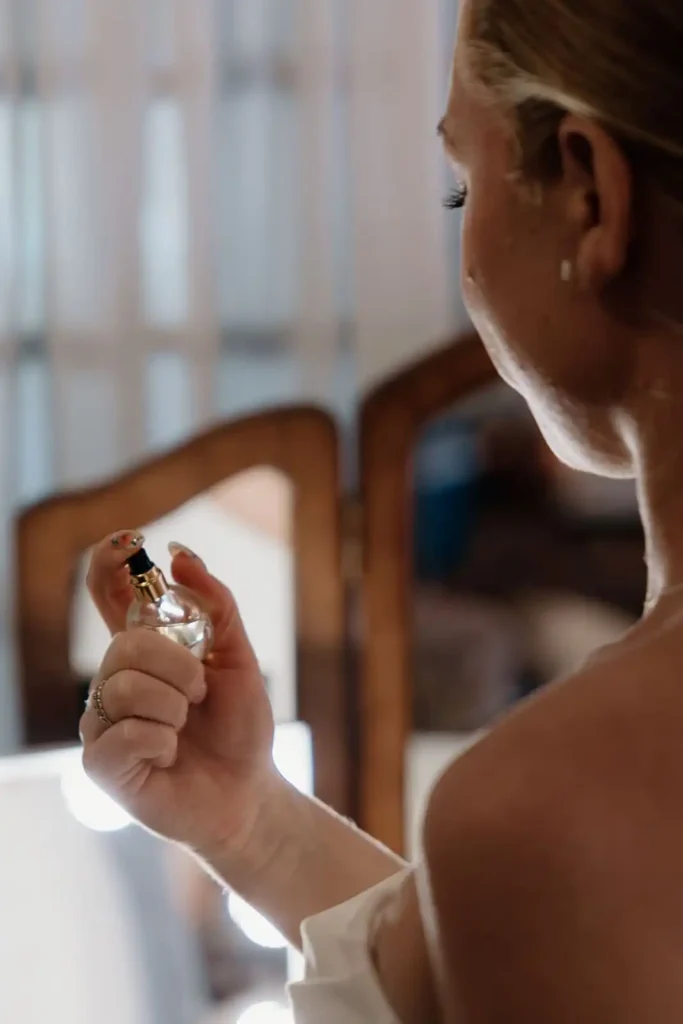 Bride spraying perfume while getting ready for wedding day - a must have wedding photography shot list moment