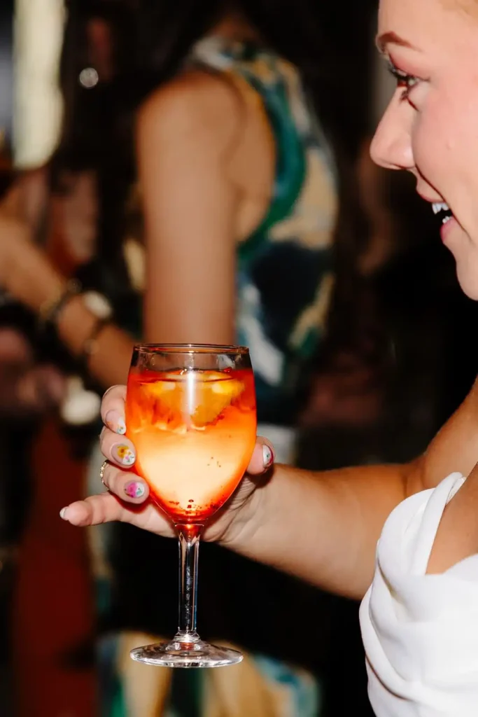 Bride sips special cocktail at wedding reception at Wellshire Event Center
