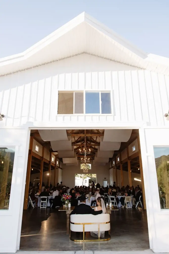 Wide shot of reception space showing indoor-outdoor flow and lake views.