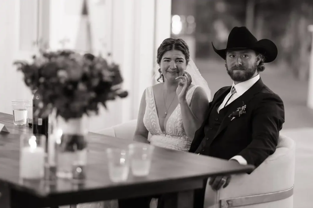Emotional black and white photo of a bride wiping away a tear during sentimental reception toasts.
