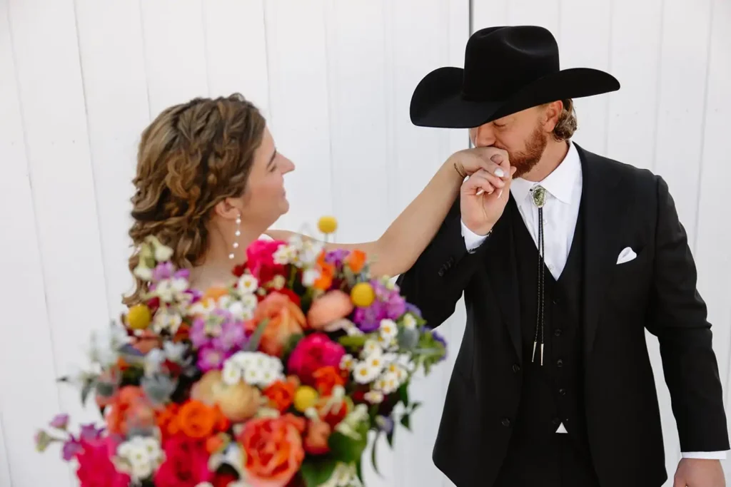 Close-up of couple holding hands during private vows at their barn wedding venue near Aspen, Colorado.