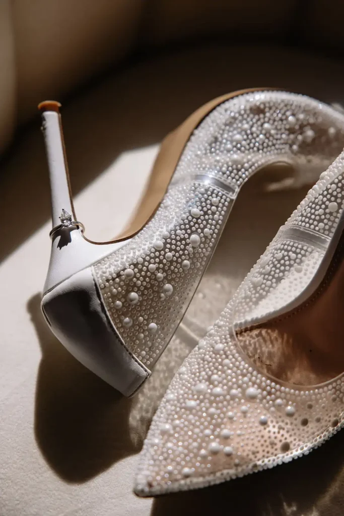 Editorial style wedding detail photos of luxury wedding shoes with pearls and unique wedding ring. 