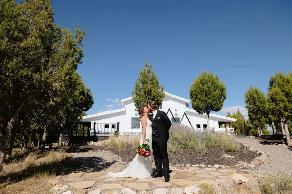Bride and Groom share a first look moment in front of Vista View Events modern barn with lakeside views and stunning Colorado landscape
