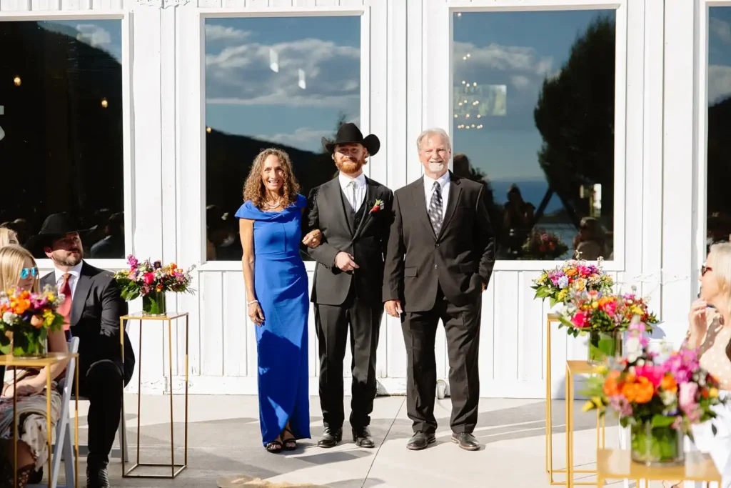 Groom walking down the aisle with parents at a western-inspired Colorado wedding near Aspen