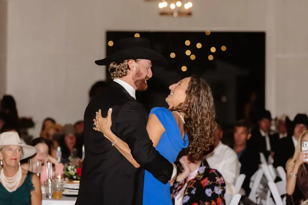 Guests dancing under string lights in Vista View Events barn with open doors to the outdoors.