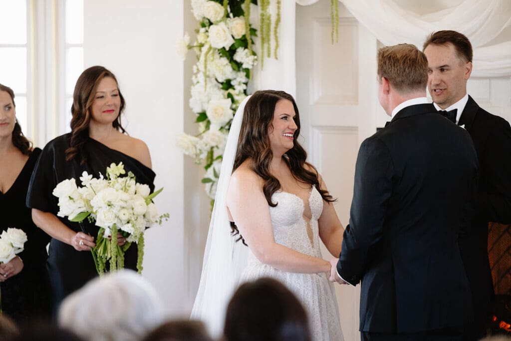 The Manor House is an elegant wedding venue near denver colorado, perfect for a winter wedding. Its indoor ceremony space with a fireplace and neutral white walls with grand chandeliers provide a cozy atmosphere for a luxury wedding day.