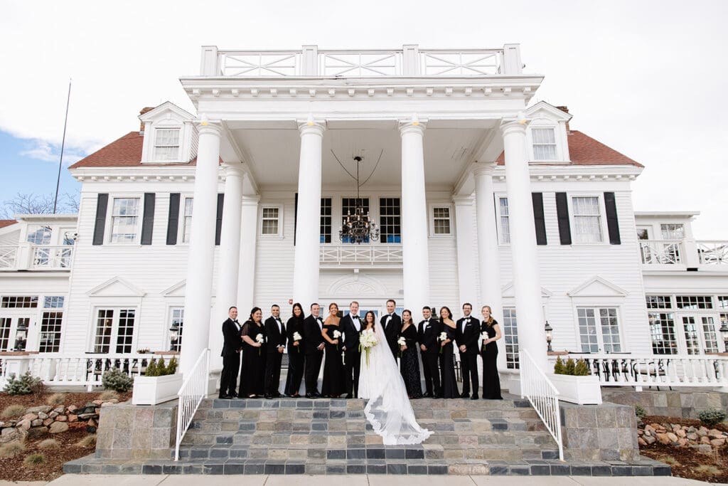 Exterior view of The Manor House wedding venue in Littleton, Colorado, featuring white columns and grand stone entrance steps. Photo taken by a Denver wedding photographer, Leah Lach Photography